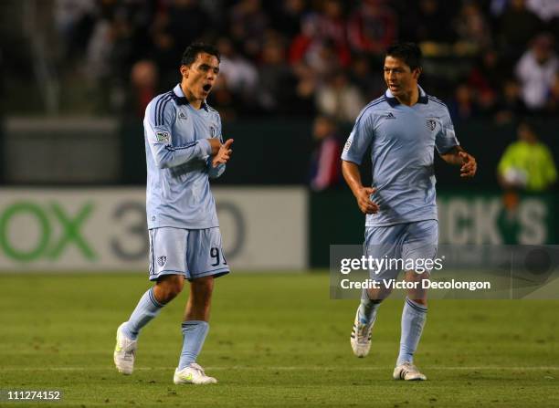 Roger Espinoza of Sporting Kansas City looks on as teammate Omar Bravo punches his hand after scoring a goal during the MLS match against Chivas USA...