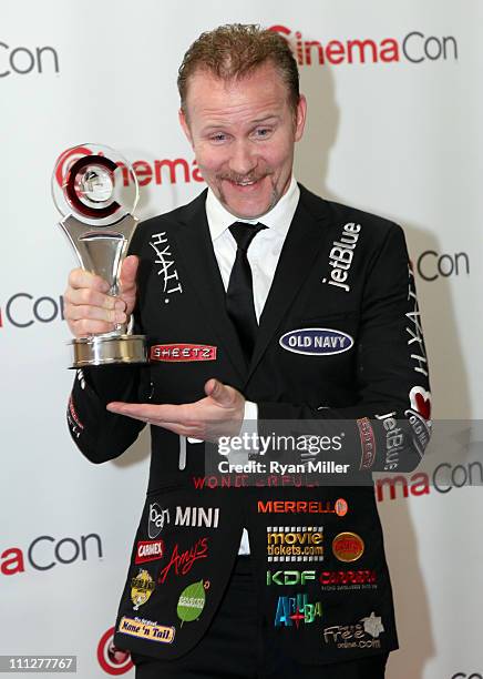 Director Morgan Spurlock poses with his Documentary Filmmaker of the Year award during CinemaCon, the official convention of the National Association...