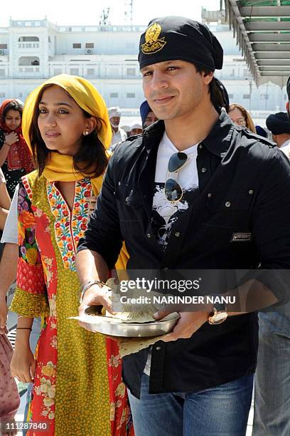 Indian Bollywood fim actor Vivek Oberoi and wife Priyanka pay their respects at the Golden temple Sikh shrine in Amritsar on March 31, 2011. AFP...