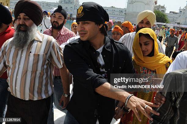 Indian Bollywood fim actor Vivek Oberoi and wife Priyanka pay their respects at the Golden temple Sikh shrine in Amritsar on March 31, 2011. AFP...