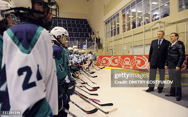 Russian President Dmitry Medvedev speaks with young ice hockey players as Alexander Yakushev , Soviet hockey superstar and winger of the national...