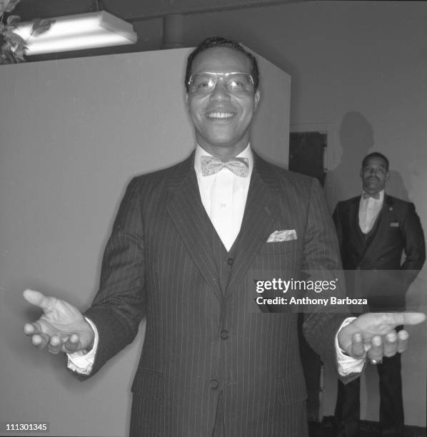 Portrait of American Islamic religious leader Louis Farrakhan, standing with arms outstretched before him, New York, 1984.