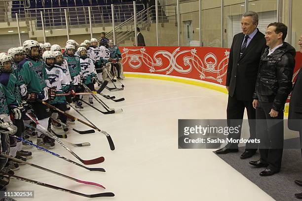 Russian President Dmitry Medvedev greets young ice hockey players, with prominent Soviet ice hockey player Alexander Yakushev standing nearby, at the...