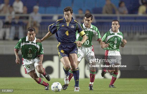 Paul Okon of Australia is chased down by several opponents, during the 2001 FIFA Confederations Cup Group A match between Mexico and Australia at the...