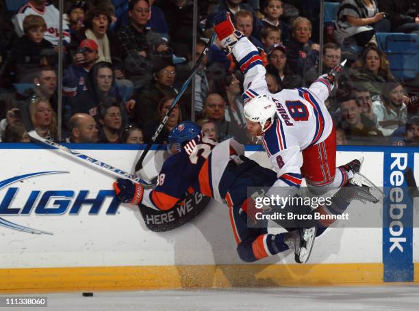 Jack Hillen of the New York Islanders flips Brandon Prust of the New York Rangers in the third period at the Nassau Coliseum on March 31, 2011 in...