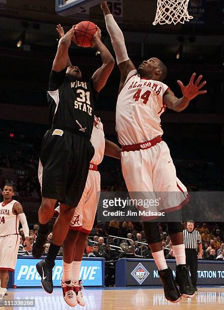 Durley of the Wichita State Shockers goes to the hoop against Chris Hines of the Alabama Crimson Tide during the 2011 NIT Championship game on March...