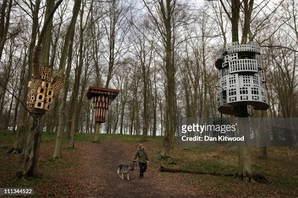 Tony Hall walks with his dog through an installation entitled 'Super Kingdom', which hangs in trees in King's Wood as part of the Stour Valley Arts...