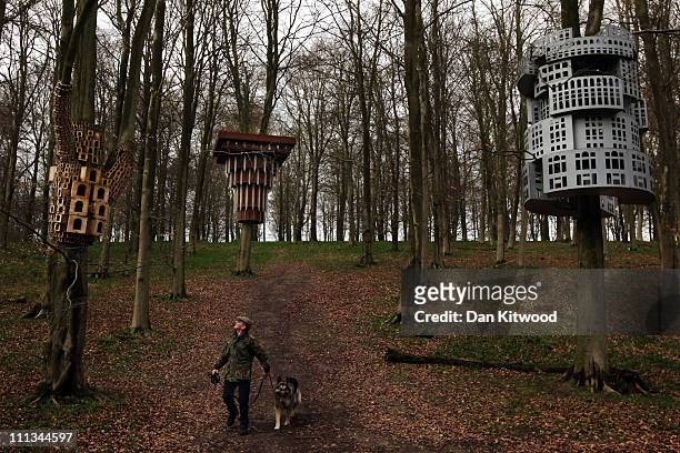 Tony Hall walks with his dog through an installation entitled 'Super Kingdom', which hangs in trees in King's Wood as part of the Stour Valley Arts...