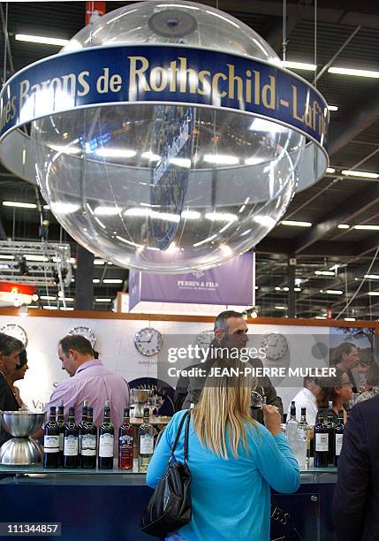 Woman tastes wine at the booth of the "Rothschild barons", 19 June 2007 during Vinexpo, the world's biggest wine and spirits trade fair in Bordeaux,...