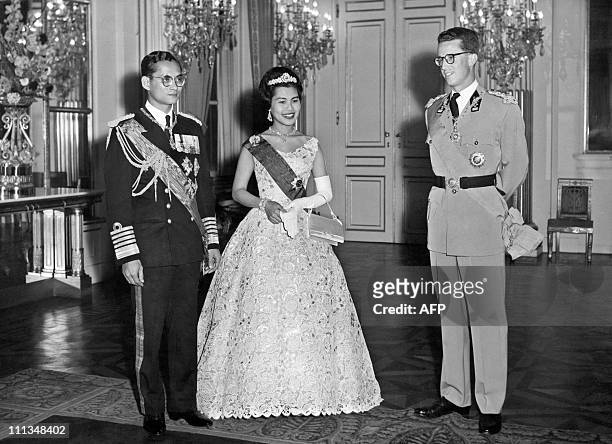 Thai King Bhumibol Adulyadej and Queen Sirikit stand near Belgium King Baudouin I, on October 1960 in Brussels, during their offcil visit to Belgium.
