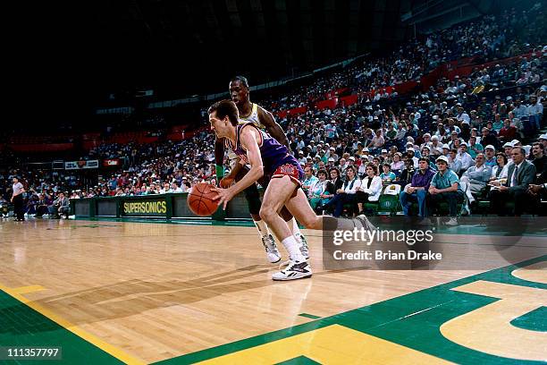 Jeff Hornacek of the Phoenix Suns dribbles against Xavier McDaniel of the Seattle Supersonics at the Seattle Coliseum in Seattle, Washington circa...