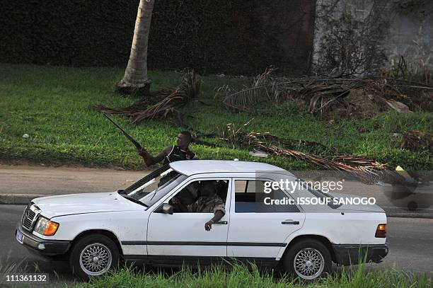 Troops loyal to Alassane Ouattara drive a vehicle along a street in Abidjan on April 1, 2011. - Ivory Coast strongman Laurent Gbagbo's forces...