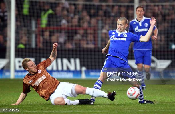 Rouwen Hennings of St. Pauli and Peer Kluge of Schalke battle for the ball during the Bundesliga match between FC St. Pauli and FC Schalke 04 at...