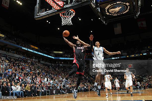 Dwyane Wade of the Miami Heat dunks against Wesley Johnson of the Minnesota Timberwolves during the game on April 1, 2011 at Target Center in...