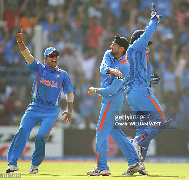 Indian spinner Harbhajan Singh is congratulated by teammates Suresh Raina and wicketkeeper Mahendra Singh Dhoni after dismissing Sri Lankan batsman...