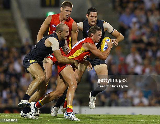 Daniel Harris of the Suns is tackled by Chris Judd of the Blues during the round two AFL match between the Gold Coast Suns and the Carlton Blues at...