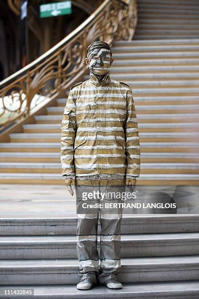 Chinese artist Liu Bolin stands at the end of a happening at the Grand Palais in Paris on April 1, 2011. Bolin, from Shandong, China, manages to...
