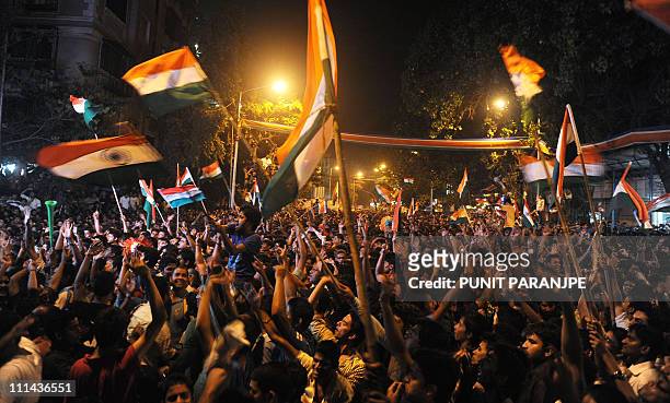 Indian fans wave national flags as they celebrate after India's victory against Sri Lanka in the Cricket World Cup 2011 final match in Mumbai on...