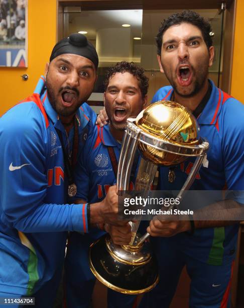 Harbhajan Singh ,Sachin Tendulkar and Yuvraj Singh with the winners trophy in the players dressing room during the 2011 ICC World Cup Final between...