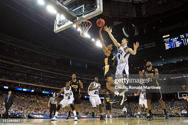 Darius Theus of the Virginia Commonwealth Rams goes to the basket against Andrew Smith of the Butler Bulldogs during the National Semifinal game of...