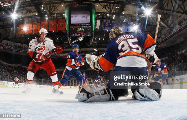 Al Montoya of the New York Islanders makes a glove save off of Eric Staal of the Carolina Hurricanes on April 2, 2011 at Nassau Coliseum in...