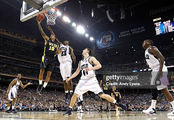 Darius Theus of the Virginia Commonwealth Rams goes to the hoop against Khyle Marshall and Andrew Smith of the Butler Bulldogs during the National...