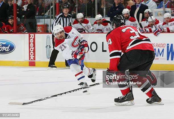 Brian Gionta of the Montreal Canadiens fires a shot while being defended by Mark Fayne of the New Jersey Devils during the game at the Prudential...