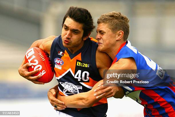 Ozgur Uysal of the Cannons is tackled by Matthew Arnot of the Chargers during the round one TAC Cup match between the Oakleigh Chargers and the...