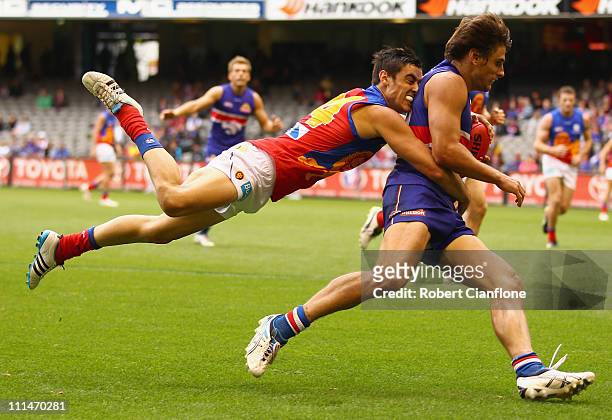 Ryan Griffin of the Bulldogs is tackled by Jesse O'Brien of the Lions during the round two AFL match between the Western Bulldogs and the Brisbane...