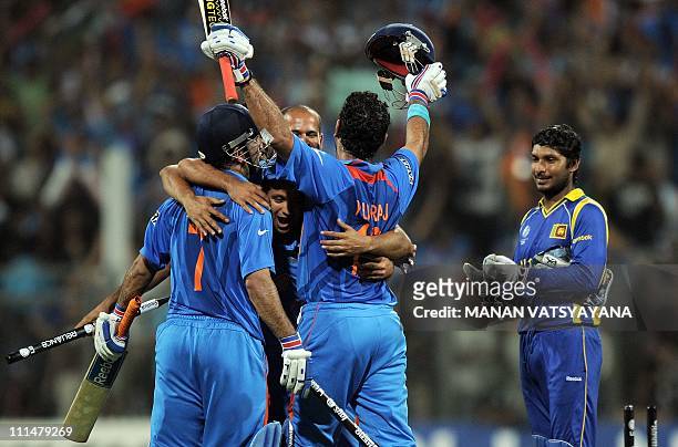 Indian cricketers celebrate after beating Sri Lanka as Sri Lankan captain Kumar Sangakkara looks dejected during the ICC Cricket World Cup 2011 final...