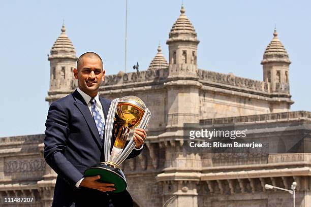 India's cricket team captain Mahendra Singh Dhoni poses with the ICC Cricket World Cup Trophy, with the Gateway of India in the backdrop, during a...