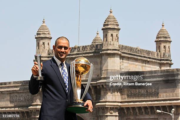 India's cricket team captain Mahendra Singh Dhoni poses with the ICC Cricket World Cup Trophy, with the Gateway of India in the backdrop, during a...