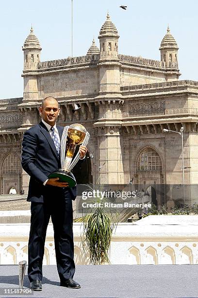 India's cricket team captain Mahendra Singh Dhoni poses with the ICC Cricket World Cup Trophy, with the Gateway of India in the backdrop, during a...