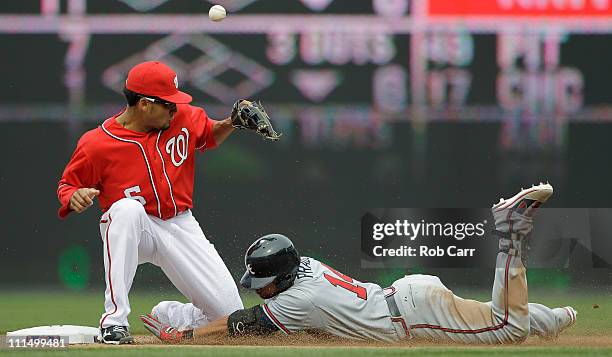 Martin Prado of the Atlanta Braves slides safely into second base for a double as shortstop Ian Desmond of the Washington Nationals bobbles the throw...