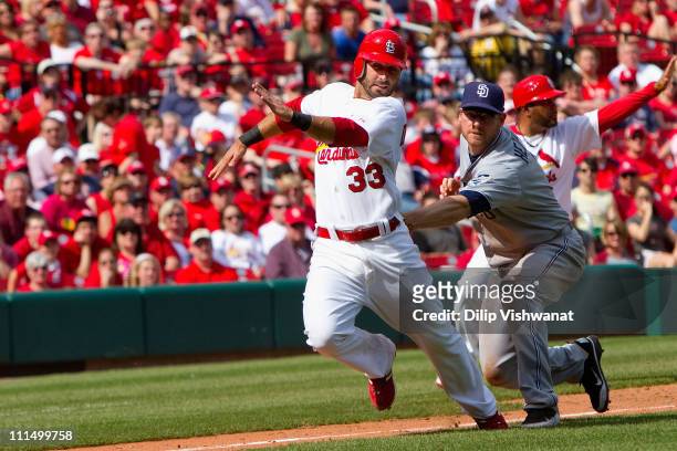 Daniel Descalso of the St. Louis Cardinals is caught in a rundown by Chase Headley of the San Diego Padres at Busch Stadium on April 3, 2011 in St....