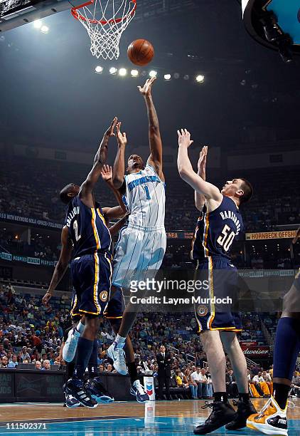 Trevor Ariza of the New Orleans Hornets shoots against Darren Collison and Tyler Hansbrough of the Indiana Pacers on April 3, 2011 at the New Orleans...