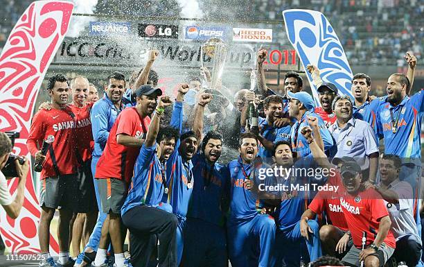 Indian cricketers pose with the trophy after victory in the Cricket World Cup 2011 final over Sri Lanka at The Wankhede Stadium in Mumbai on April 2,...