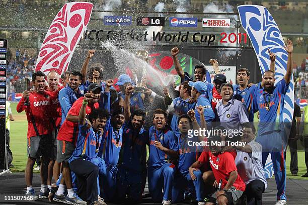 Indian cricketers pose with the trophy after victory in the Cricket World Cup 2011 final over Sri Lanka at The Wankhede Stadium in Mumbai on April 2,...