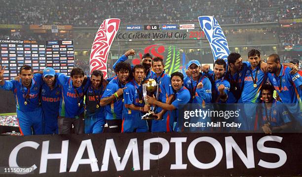 Indian cricketers pose with the trophy after victory in the Cricket World Cup 2011 final over Sri Lanka at The Wankhede Stadium in Mumbai on April 2,...