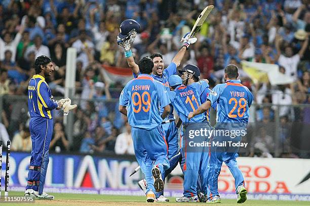 Sri Lanka's captain Kumar Sangakkara, left, looks on as India's captain Mahendra Singh Dhoni, center back, and Yuvraj Singh greeted by Ravichandran...