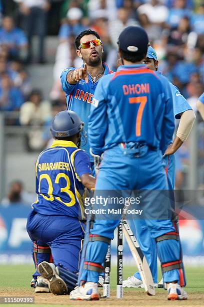 India's Yuvraj Singh discusses with captain and wicketkeeper Mahendra Singh Dhoni whether they should refer the LBW shout against Sri Lanka's Thilan...