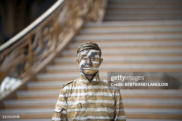 Chinese artist Liu Bolin stands at the end of a happening at the Grand Palais in Paris on April 1, 2011. Bolin, from Shandong, China, manages to...