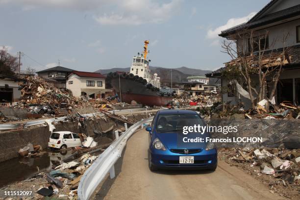 Car travels a road past debris April 3, 2011 in Ohfunato, Japan. The 9.0 magnitude strong earthquake struck offshore on March 11 at 2:46pm local...