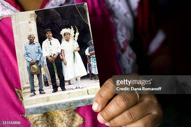 Naomi Cruz Cruz holds a photographo of her taken on her wedding day with her father and her husband on February 22, 2008 in Tlacolula. Naomi married...