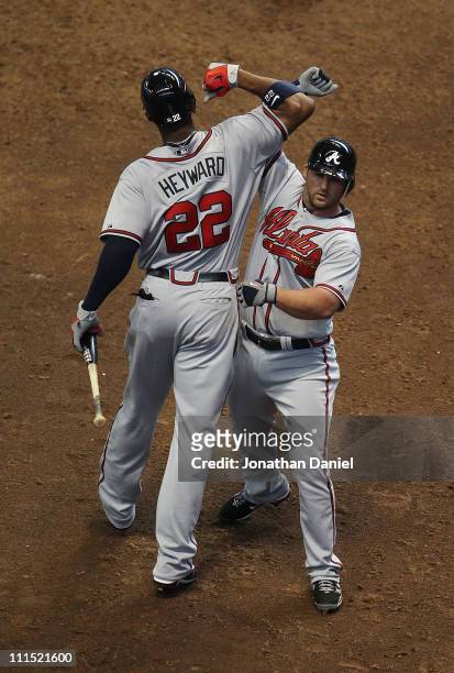 Dan Uggla of the Atlanta Braves celebrates a solo home run in the 8th inning with teammate Jason Heyward against the Milwaukee Brewers during the...