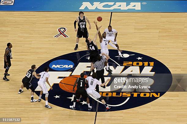 Andrew Smith of the Butler Bulldogs tips the ball off against Alex Oriakhi of the Connecticut Huskies to start the National Championship Game of the...