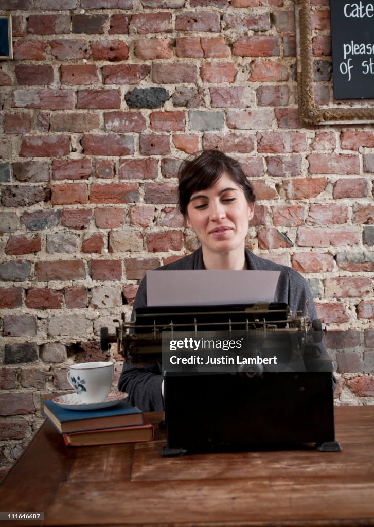 Girl Using Typewriter Girl Smilin Using Antique Typewriter In Cafe High-Res Stock Photo ...