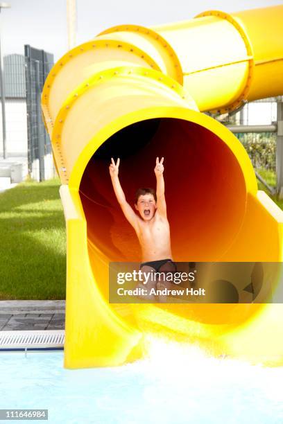 young boy on waterslide in reykjavík, iceland - water slide stock pictures, royalty-free photos & images