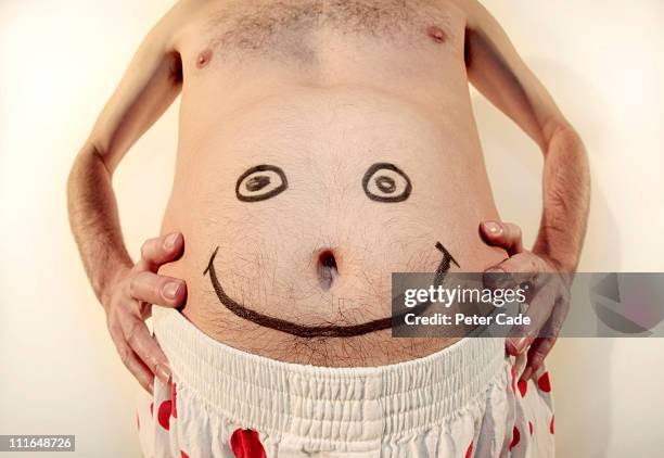 mans belly with smiley face drawn on - fat guy belly stock pictures, royalty-free photos & images