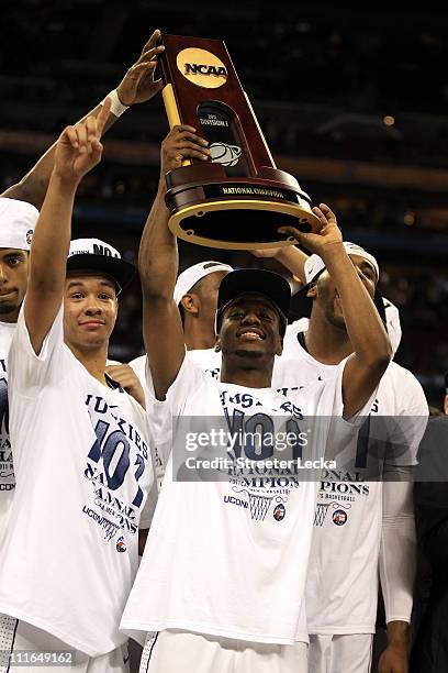 Shabazz Napier and Kemba Walker of the Connecticut Huskies celebrate with the trophy after defeating the Butler Bulldogs to win the National...